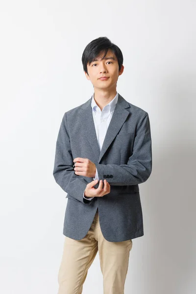 Νεαρός Ιάπωνας Στολή Γραφείου Στέκεται Και Κοιτάζει Την Κάμερα — Φωτογραφία Αρχείου