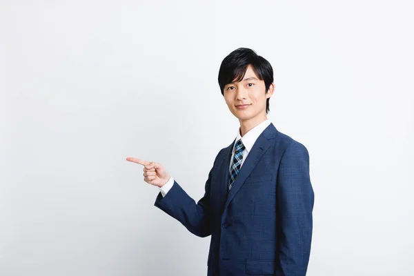 Joven Hombre Negocios Japonés Traje Oficina Mostrando Gesto Señalando —  Fotos de Stock