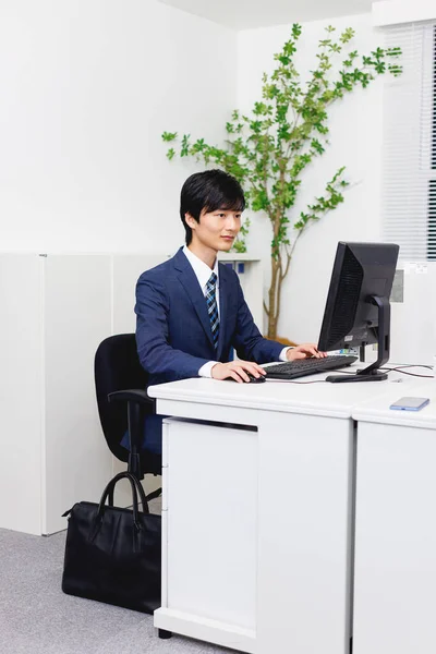 Νεαρός Ιάπωνας Επίσημη Ενδυμασία Εργάζεται Στο Σύγχρονο Γραφείο — Φωτογραφία Αρχείου