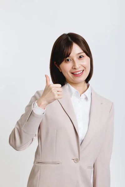 オフィスの服装の若い日本人女性が親指を示すジェスチャー — ストック写真
