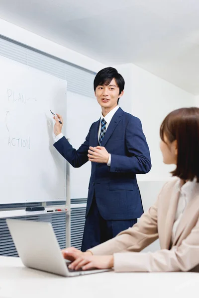 Junger Japaner Bürokleidung Präsentiert Seiner Kollegin Businessplan — Stockfoto