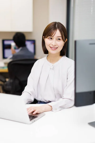 現代のオフィスでラップトップに取り組んでいる美しい日本人女性の肖像画 — ストック写真