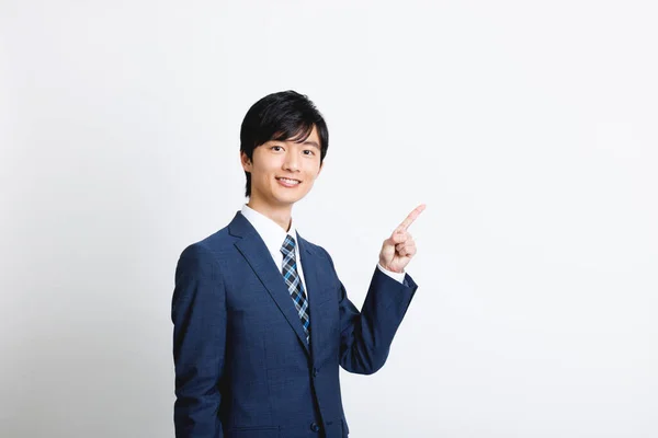 オフィスの服装の若い日本人男性がジェスチャーを指す — ストック写真