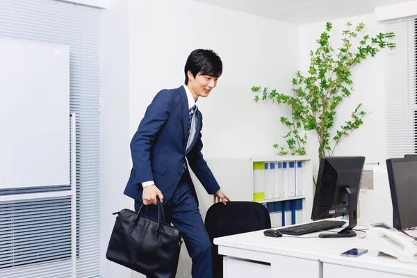 Young Japanese man in office attire working in the modern office