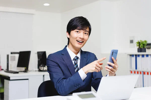 在办公室用手机的日本年轻人 — 图库照片