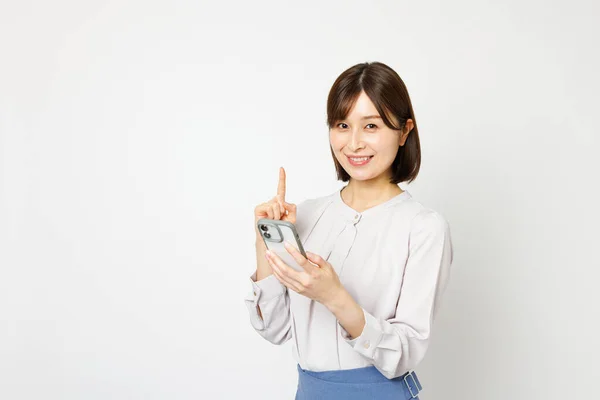 Ofisteki Genç Japon Kadın Akıllı Telefon Kullanırken Işaret Işareti Gösteriyor — Stok fotoğraf