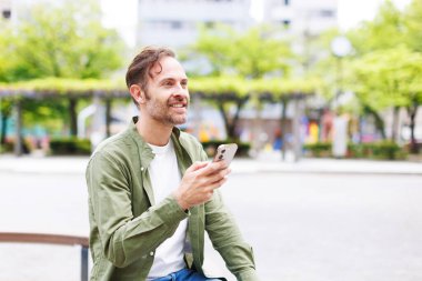 Japonya 'da açık havada cep telefonu kullanan beyaz bir adam.