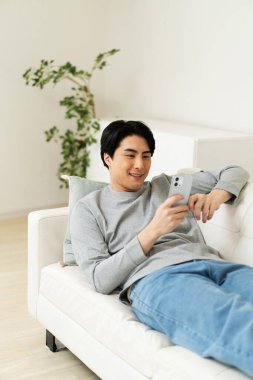 Evde cep telefonu kullanan bir Japon.