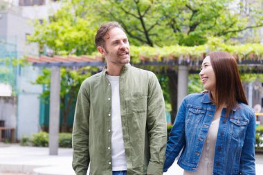 Yaz parkında yürüyen sevgi dolu bir çift. Aşık romantik bir çiftin açık hava portresi. 