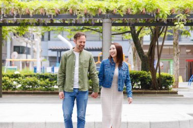 Yaz parkında yürüyen sevgi dolu bir çift. Aşık romantik bir çiftin açık hava portresi. 