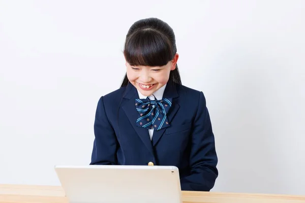 オンラインクラスに参加する学校制服の日本人少女 — ストック写真