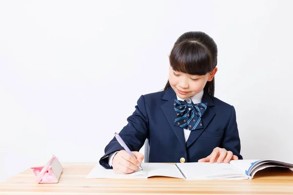学校の制服でかわいい日本の女の子の肖像 宿題をする — ストック写真