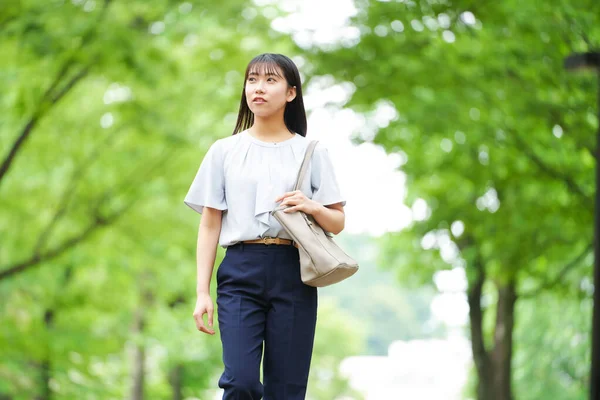 Parkta yalnız yürüyen güzel bir Japon kadının portresi. 