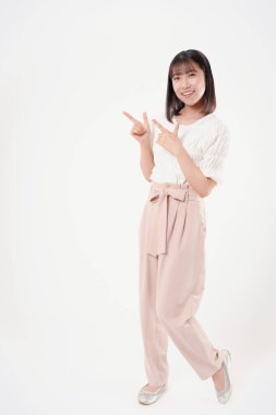 Güzel Japon kadın beyaz arka planda izole bir şekilde bir şeyi işaret ediyor.