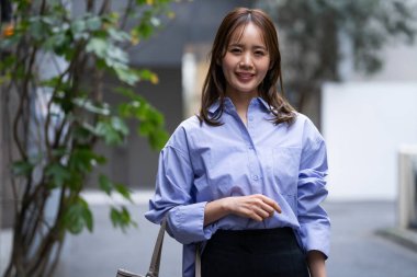 Sokakta yürüyen genç Japon kadın, gündüz görüşü. 