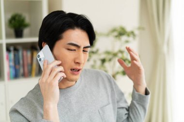 Evde cep telefonu kullanan bir Japon.