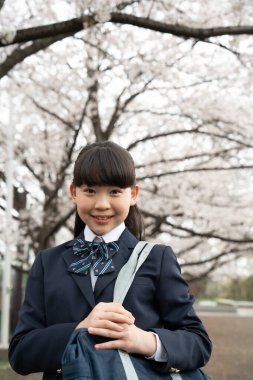 Okul çantalı, kiraz çiçekli Asyalı kız.