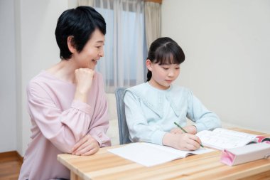 Küçük kızıyla birlikte okuyan genç bir anne.