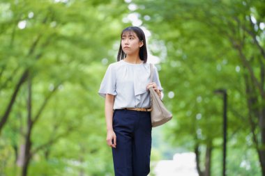 Parkta yalnız yürüyen güzel bir Japon kadının portresi. 