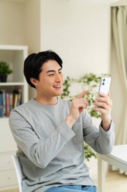 Evde cep telefonu kullanan bir Japon.