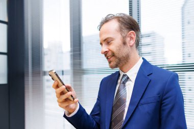 Ofisteki cep telefonlu genç işadamının portresi.