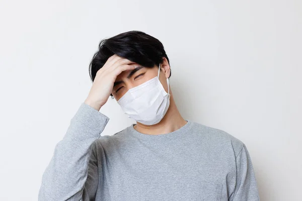 Jonge Aziatische Man Het Gezicht Masker Met Hoofdpijn Geïsoleerde Achtergrond — Stockfoto