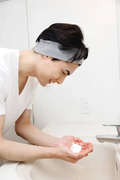 Portret Przystojnego Młodego Japończyka Myjącego Twarz Podczas Porannej Rutyny Domu — Zdjęcie stockowe