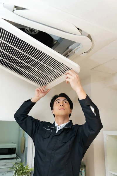 Japanese Worker Fixing Air Conditioner — Stock Photo, Image