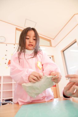 Anaokulunda oynayan küçük tatlı Asyalı kız.