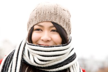 Şapkalı ve atkılı genç Asyalı kadın portresi