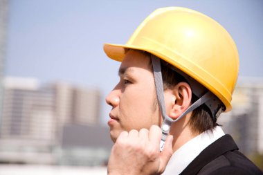 Şehirde miğfer takan Asyalı adam.