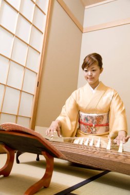 Japon kadın Asyalı geleneksel ip enstrümanı çalıyor 