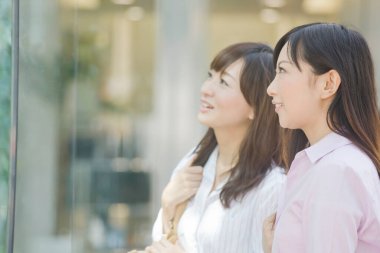 Pencereden bakan Asyalı kadınlar