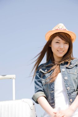 Açık havada bavullu Asyalı kadın. 