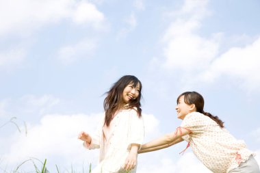 Genç Asyalı kadınlar sahada eğleniyor.