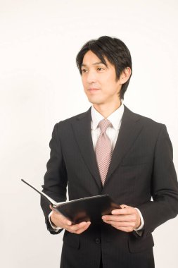 Beyaz arka planda yakışıklı genç Japon işadamının yakın plan portresi.