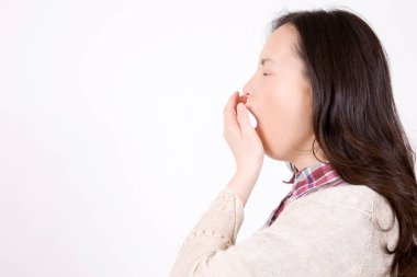 Beyaz arka planda tek başına esneyen güzel genç bir kadının yan görünümü