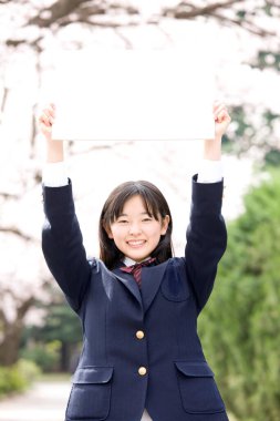 Genç Japon kız öğrenci beyaz boşluk gösteriyor. 