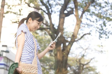 Şehirde cep telefonu kullanan Japon kadın.
