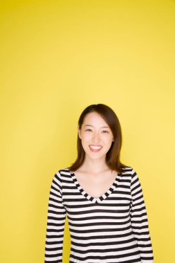 Güzel genç Asyalı kadın kameraya bakıyor, stüdyo görüntüsü.