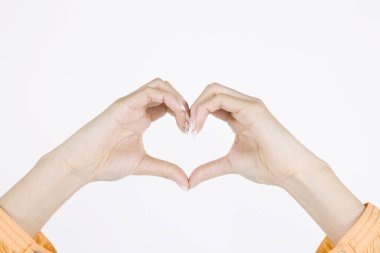 Beyaz arka planda kalp şekillendiren kadın elleri