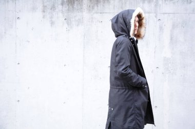 Kapüşonlu köknar giymiş genç Asyalı adam.