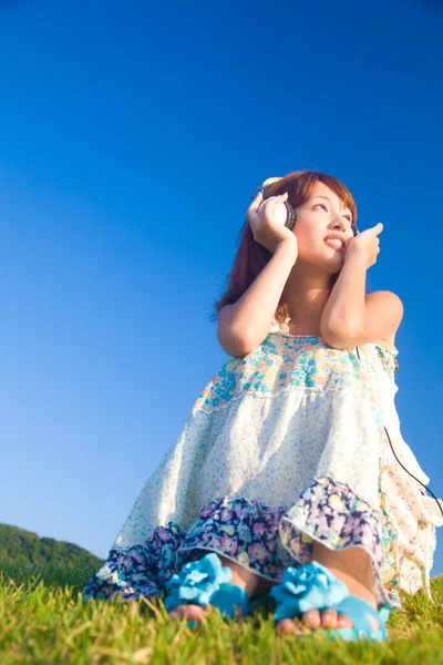 Vacker Asiatisk Ung Kvinna Lyssnar Musik Med Hörlurar Medan Sitter — Stockfoto