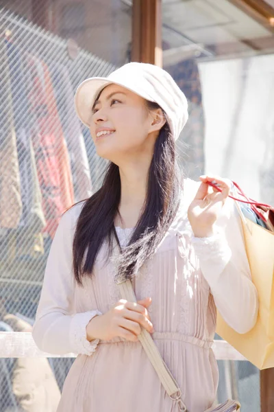 在城市里拿着购物袋的美丽而快乐的年轻亚洲女人 — 图库照片