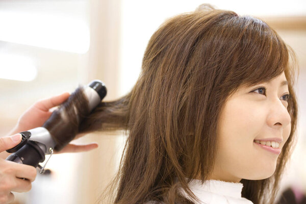 Young Japanese woman doing hairdressing in salon. Beauty Japanese lady making stylish haircut 