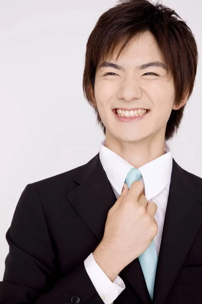 Νεαρός Ιάπωνας Προσαρμόζει Γραβάτα Απομονωμένο Φόντο — Φωτογραφία Αρχείου