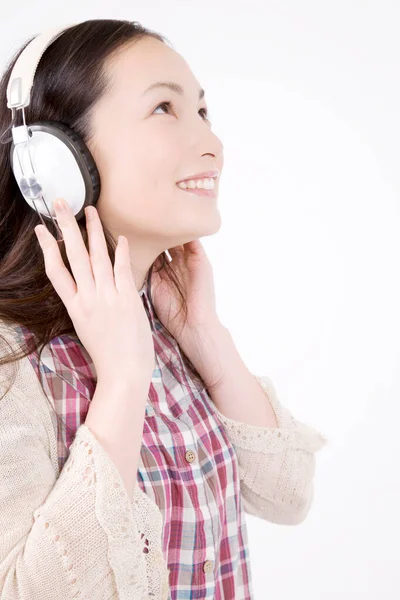 白い背景に隔離されたヘッドホンで音楽を聞く美しい幸せな若い女性の肖像画 — ストック写真