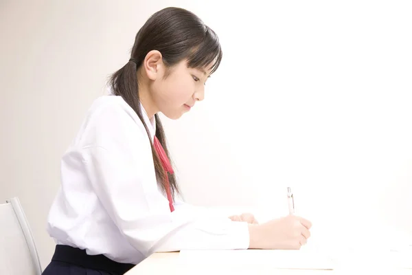 Młoda Japońska Uczennica Pisząca Notatki Podczas Nauki Szkole — Zdjęcie stockowe