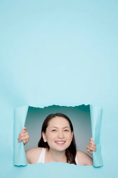 Japon Kadının Portresi Yırtık Mavi Kağıttaki Delikten Bakıyor — Stok fotoğraf