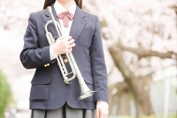 公園のトランペットと学校の制服のかわいい女の子 — ストック写真